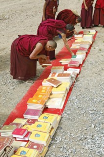 Monks looking at books on the floor