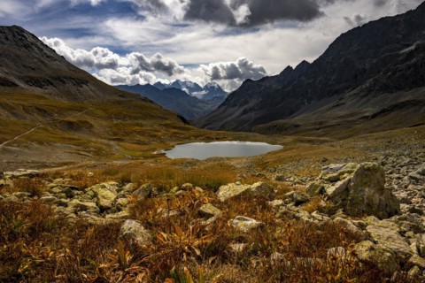 Mountain lake Lej Suvretta with Bernina group and Engadine mountains with cloudy sky
