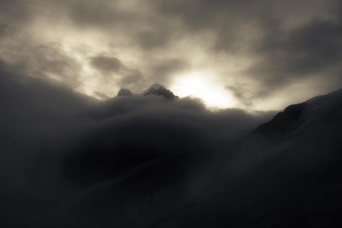 Peak of Piz Rosegg in dramatic clouds at blue hour