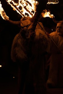 Klausen mask with burning horns and trident in the dark