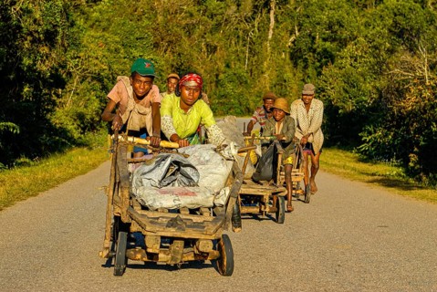 Young boys pushing self made carts up the hill