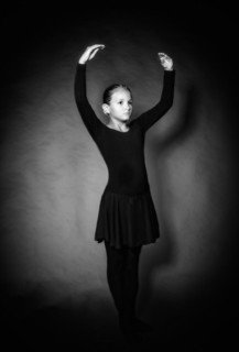 Young girl in dancewear stands in position