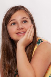 Portrait of a girl with long hair supporting her chin with her hand