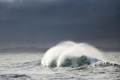 Big wave breaks in winter storm in open sea and dramatic light off north coast of Ireland