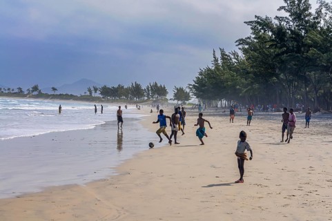 Boys playing soccer on the beach