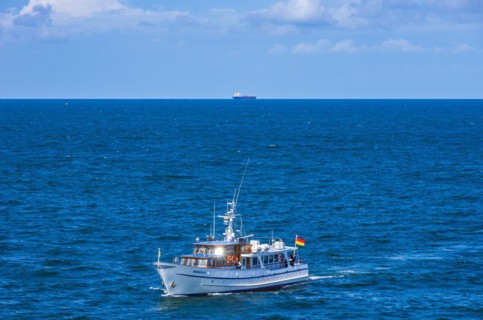 The motor yacht Merkur II returns from a burial at sea and enters the home port of Rostock-Warnemuende