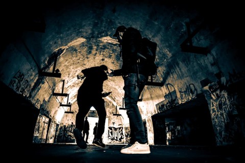 Two men as silhouette in bunker with graffiti walls