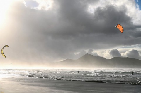 Kitesurfers at sunset on the beach of Caleta de Famara