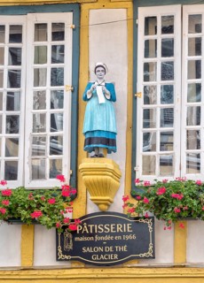 Detail of the half-timbered house with statue of a woman in historical traditional costume in the Rue Kereon