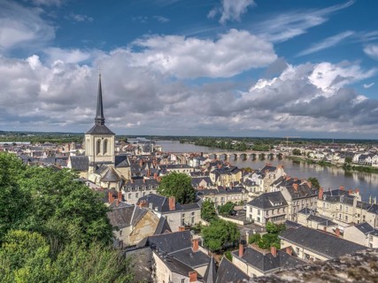 Panorama of the town of Saumur with the dominating bell tower of the Eglise Saint-Pierre-du-Marais and the Loire with the old bridge Pont Cessart