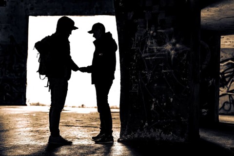 Two men as silhouette in bunker with graffiti walls
