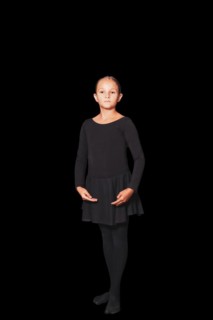 Young girl in dancewear stands in position