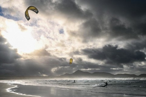 Kitesurfers at sunset on the beach of Caleta de Famara