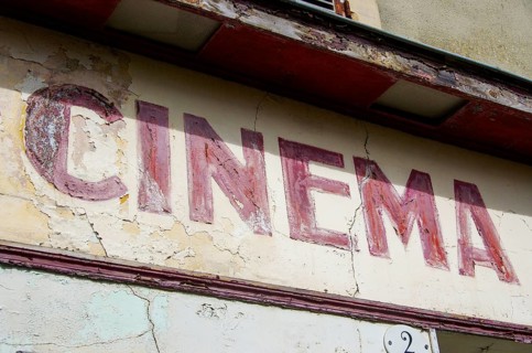 Faded old French lettering Cinema on a house facade in France