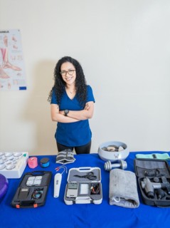 Physiotherapist with physiotherapy accessories. Smiling physiotherapist showing physiotherapy accessories