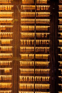 Shop display of dozens of golden bracelets and bangles