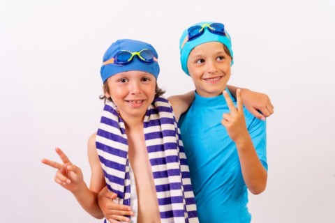 Brothers dressed and hugged in their swimsuits for swimming lessons in the pool in the summer. White background