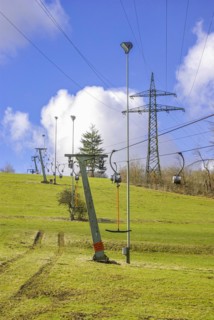 Ski lift at standstill due to lack of snow caused by climate change at the end of winter on a hill in Muensingen