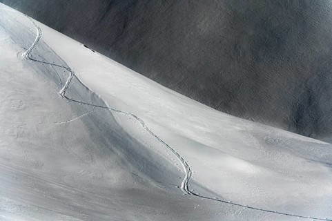 Ski touring trail in deep snowy mountain landscape with light and shadow