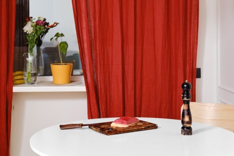 Fresh raw duck breast on wooden cutting board on kitchen table