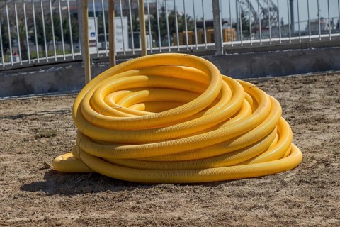 Yellow plastic water hose closeup in the view