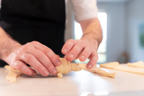 Hands of a man baking croissants