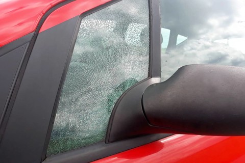 Broken front side car glass fractured into countless small pieces