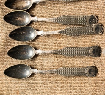 Stylish steel teaspoons on a textured background in display