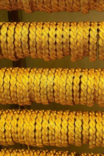 Shop display of dozens of golden bracelets and bangles