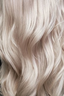 Young woman in a hairdressing salon dyes her hair blond. beauty face and hair. Back view