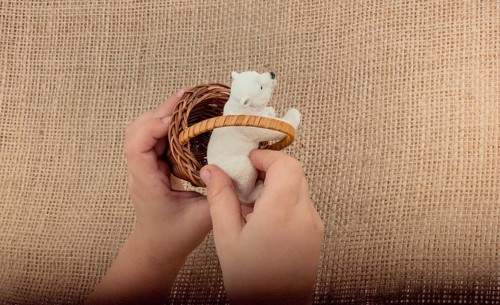 Hand holding a Polar bear model in hand on canvas