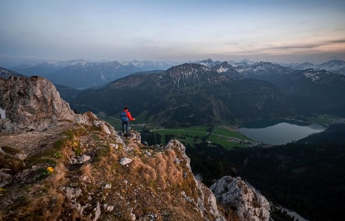 Hiker at the summit of Schartschrofen at sunset