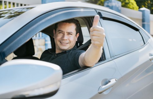 Man in his car giving thumbs up