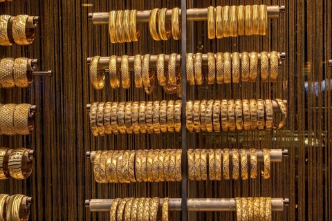 Shop display of dozens of golden bracelets and bangles