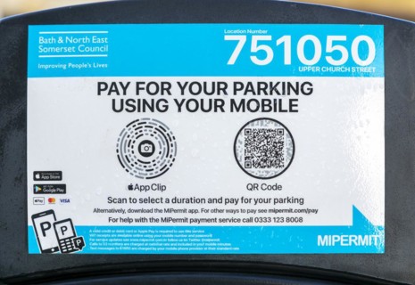 Close up of pay for parking using mobile phone sign