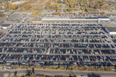 Ford pickup trucks are parked in a vacant warehouse parking lot