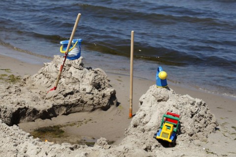 Toy and beach castle on a sandy beach by the sea