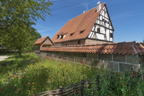 Reconstruction of a medieval bathhouse enclosed by a wall with plain tiles