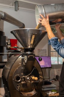 Green coffee is poured into the roasting machine
