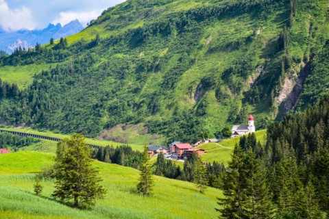 View of Damuels and the village church of Sankt Nikolaus in the Bregenzerwald in the background the Rote Wand