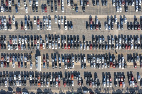 Ford pickup trucks are parked in a vacant warehouse parking lot
