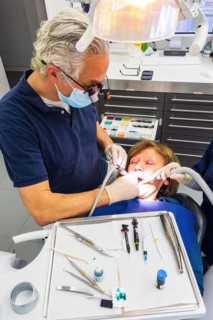 Dentist does dental prophylaxis performs dental treatment caries treatment