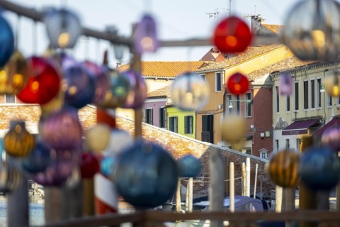 Glass art hangs in the alleys in front of colourful houses