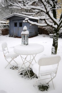 Garden table with chairs under a blanket of snow in winter