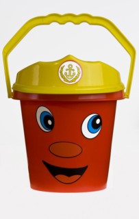 A bright red plastic childs bucket with a yellow handle and a smiley face