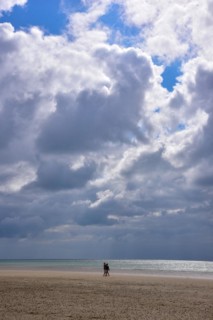 A couple taking a walk on the beach at low tide
