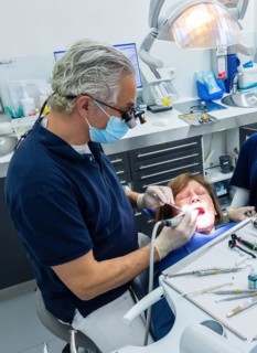 Dentist does dental prophylaxis performs dental treatment caries treatment