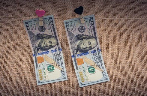 American 100 dollar banknotes with a heart clip on a string
