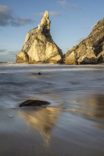 Sunset on sandy beach with rocks