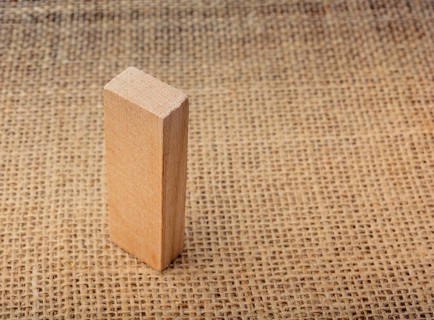 Wooden domino on a linen canvas background